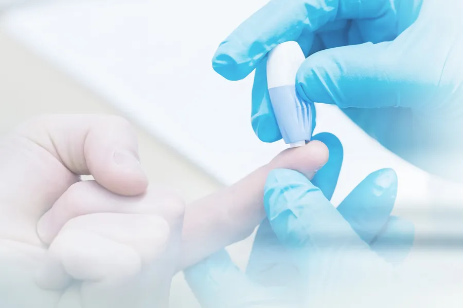 A doctor's gloved hand pricks a patients finger with to measure blood sugar, symbolizing diabetes treatment from Vida Integrative Health of Miami in Miami.