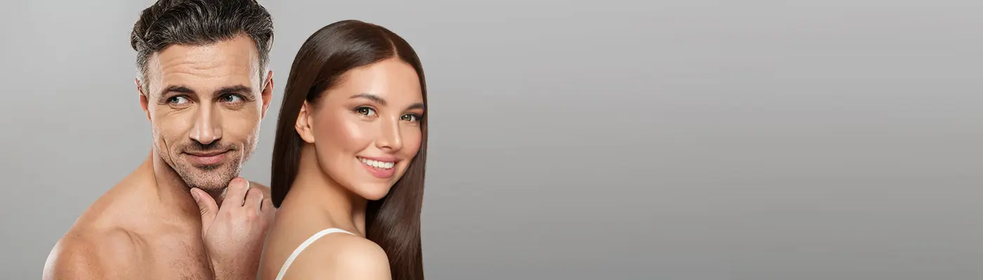 A beautiful middle-aged man and woman with great skin against a gray background, happy with the aesthetics care from Vida Integrative Health of Miami in Miami.