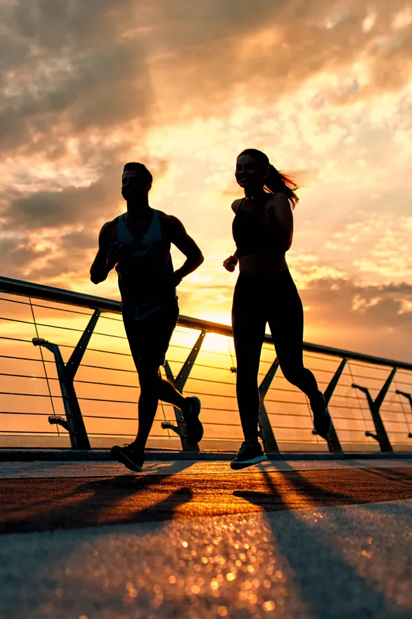 A man and woman running at sunrise, invigorated from bioidentical hormone therapy treatments from Vida Integrative Health of Miami in Miami.