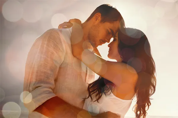 A man and a woman gaze into each others eyes while embracing in a sparkling light environment, signifying sexual wellness treatment from Vida Integrative Health of Miami in Miami.