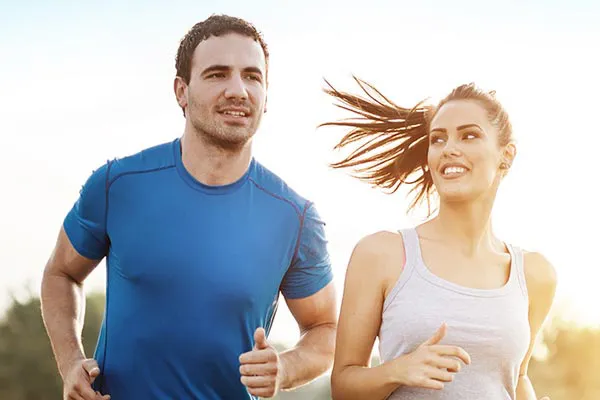 A happy man and woman jogging outdoors, happy with their hormone therapy for weight loss resistance care from Vida Integrative Health of Miami in Miami.